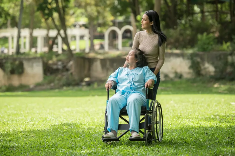 A support worker accompanying a wheelchair user outdoors