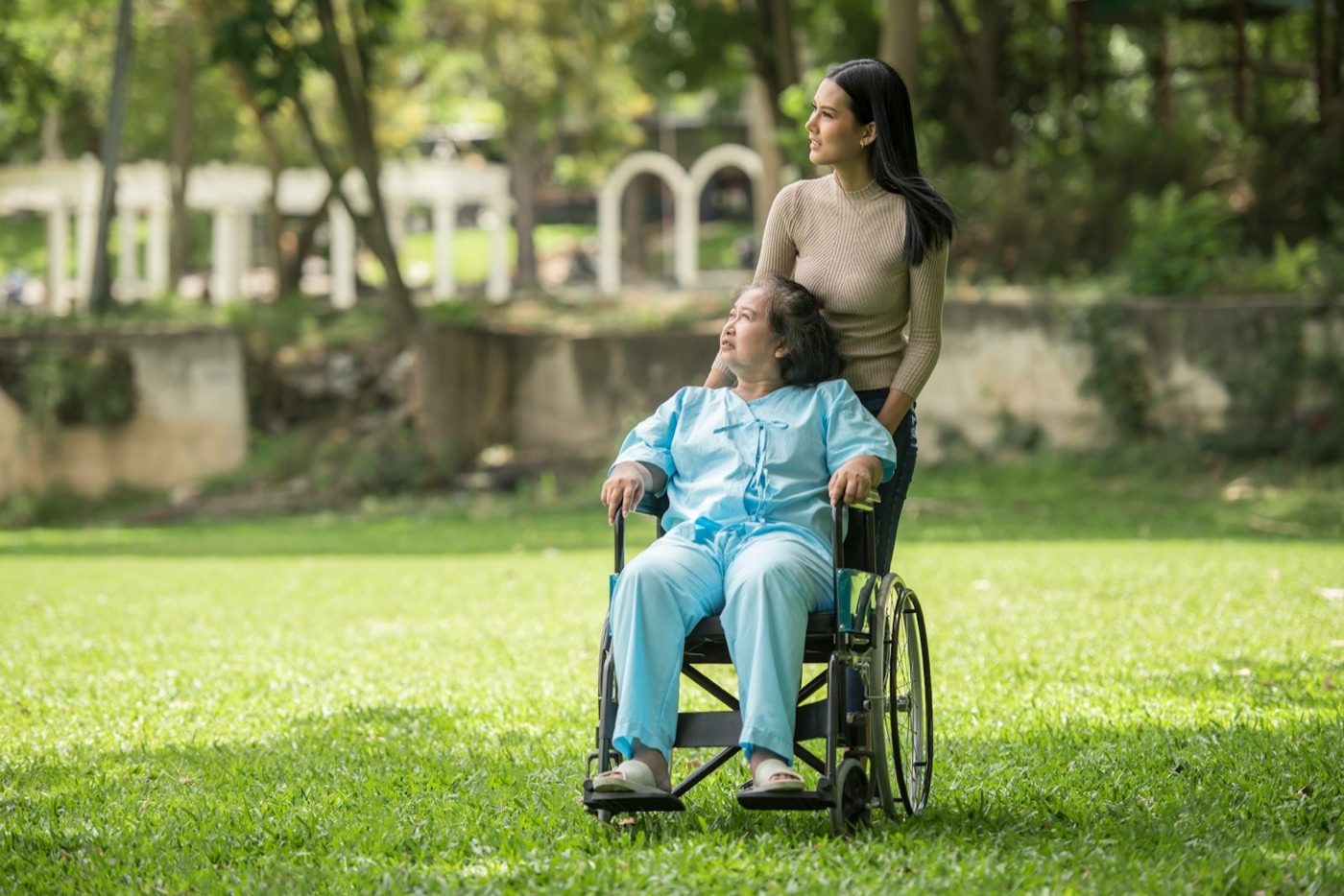A support worker accompanying a wheelchair user outdoors