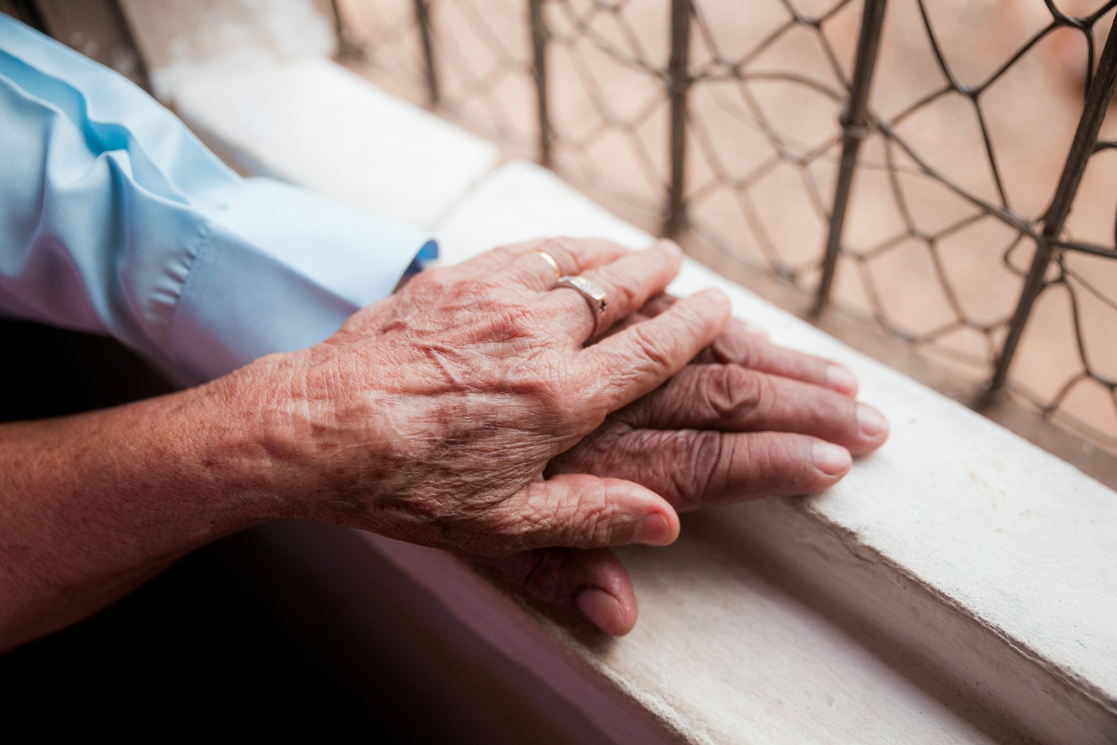 An older person holding another person’s hand